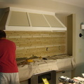 Tiling the stove wall.
