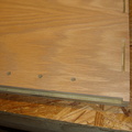 Closeup of the inside of the side panel showing the biscuits, the holes for mounting the shelf, and the rabbet created to hold t