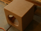 Holes are cut; corners rounded over, sanded smooth. This is the woofer's hole.